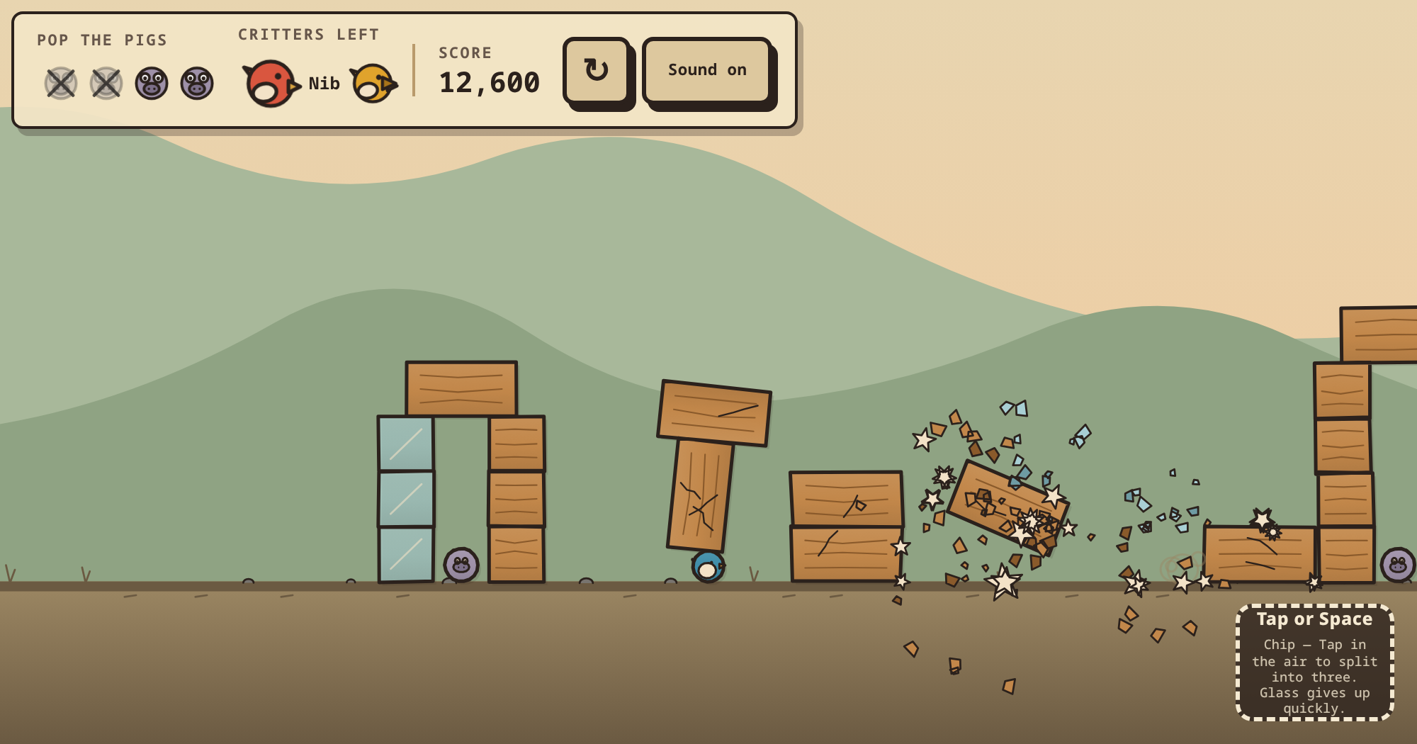SLINGWRECK in play: a wooden and glass pig fortress coming apart mid-shot, debris in the air